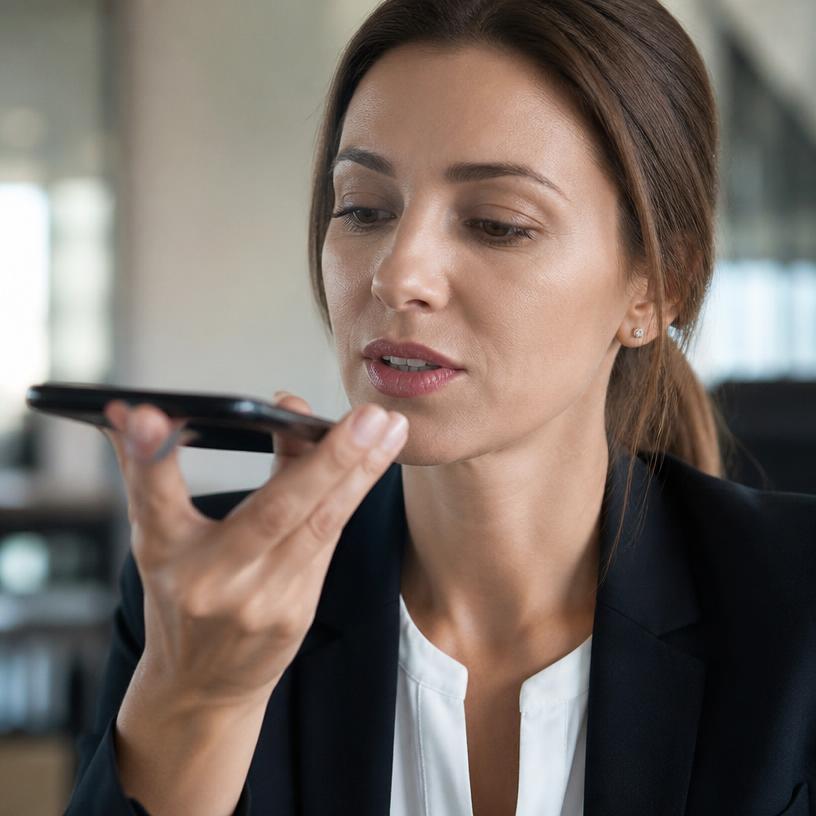 A professional dictating into a phone held near her mouth